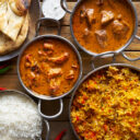 assortment of indian curry and rice dishes shot from overhead composition