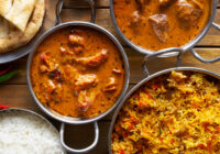 assortment of indian curry and rice dishes shot from overhead composition